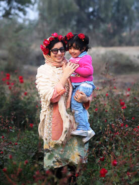 Mehak holding smiling niece amid rose field