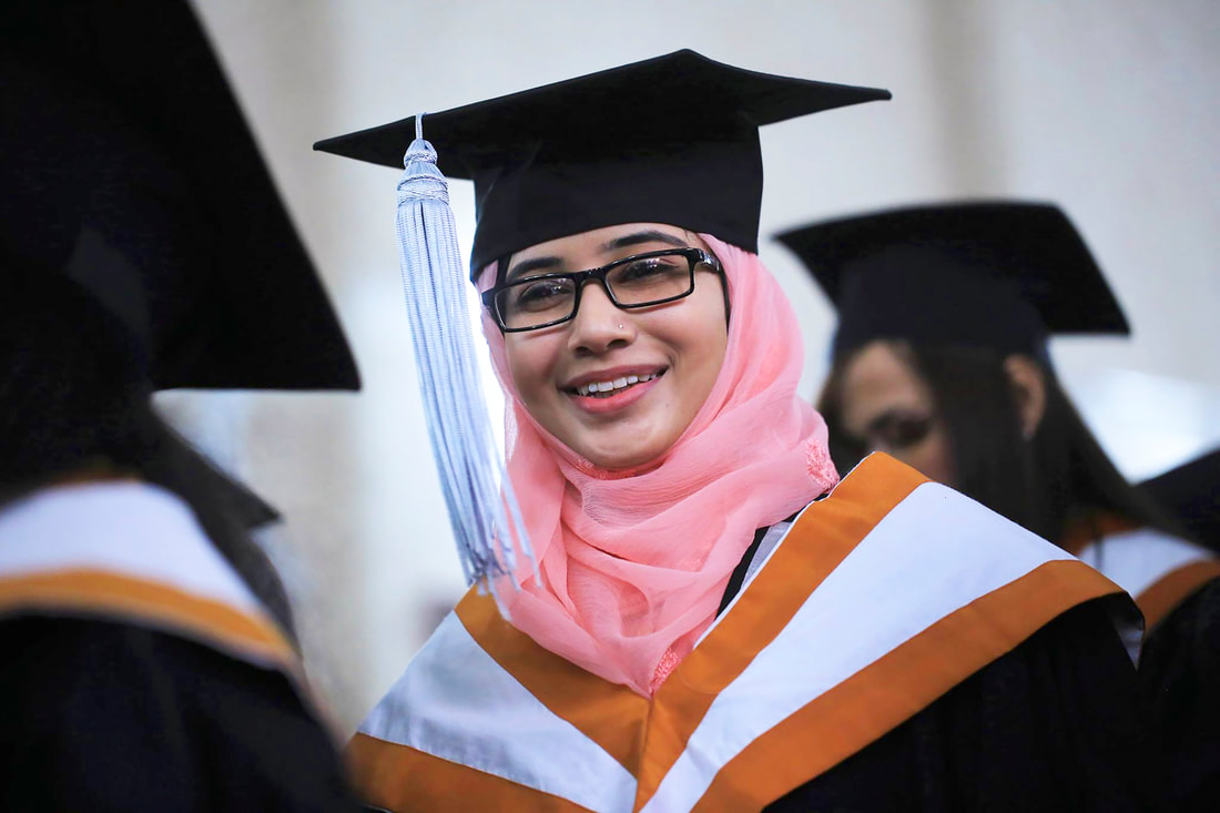 Young female graduate in hijab and academic robes